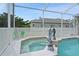 Relaxing hot tub with dolphin statues near the pool with a screened enclosure at 7511 Melogold Cir, Land O Lakes, FL 34637