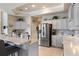 Modern kitchen with stainless steel appliances, white cabinetry, and a central island with bar seating at 7511 Melogold Cir, Land O Lakes, FL 34637