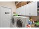 Organized laundry room with white cabinets, washer, dryer, and functional storage solutions at 7511 Melogold Cir, Land O Lakes, FL 34637