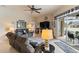 Comfortable living room with leather furniture, ceiling fan, and sliding door access to the lanai at 7511 Melogold Cir, Land O Lakes, FL 34637