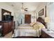 Cozy main bedroom with dark wood furniture, ceiling fan, and a large window with natural light at 7511 Melogold Cir, Land O Lakes, FL 34637