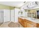 Bathroom featuring double sinks, vanity lighting, and a glass-enclosed shower at 7925 Calindra Ct, Trinity, FL 34655