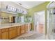 Bathroom featuring double sinks, walk-in shower, and adjacent access to a spacious bedroom at 7925 Calindra Ct, Trinity, FL 34655