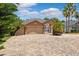 Daytime exterior view of the home, highlighting its three-car garage and tropical landscaping at 7925 Calindra Ct, Trinity, FL 34655
