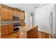 Kitchen featuring wood cabinets, granite countertops, a tiled backsplash, stainless steel appliances, and a center island at 7925 Calindra Ct, Trinity, FL 34655