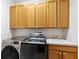 Well-equipped laundry room with washer, dryer, utility sink, ample cabinet space, and modern appliances at 7925 Calindra Ct, Trinity, FL 34655