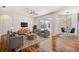 Comfortable living room features wood floors, neutral furniture, and access to a screened patio at 7925 Calindra Ct, Trinity, FL 34655