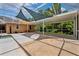 Large enclosed patio area includes tarps for shade, an outdoor shower, and a view of the pool at 7925 Calindra Ct, Trinity, FL 34655