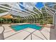 Enclosed pool area with a pool and hot tub surrounded by a large patio, perfect for outdoor entertainment at 7925 Calindra Ct, Trinity, FL 34655