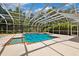 Enclosed pool area with a pool and hot tub surrounded by a large patio, perfect for outdoor entertainment at 7925 Calindra Ct, Trinity, FL 34655