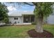 Backyard view of screened lanai, charming patio, mature tree and green lawn at 9348 Villa Entrada, New Port Richey, FL 34655