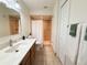 Well-lit bathroom boasts modern fixtures, a tiled shower, and ample cabinet space, creating a clean and functional design at 9348 Villa Entrada, New Port Richey, FL 34655