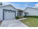 Charming single-story home featuring a well-manicured lawn and attached two-car garage at 9348 Villa Entrada, New Port Richey, FL 34655