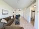 Bright living room features tile floors, a comfortable sofa, and views of the dining area at 9348 Villa Entrada, New Port Richey, FL 34655