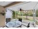 Enclosed porch featuring neutral furniture, a ceiling fan, and beautiful views of the outdoors at 9348 Villa Entrada, New Port Richey, FL 34655