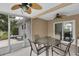 Enclosed porch featuring neutral furniture, a ceiling fan, and beautiful views of the outdoors at 9348 Villa Entrada, New Port Richey, FL 34655