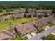 Expansive aerial view showcases the community's lush greenery and well-maintained homes in a park-like setting at 9636 Brookdale Dr, New Port Richey, FL 34655