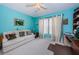 Bedroom with vibrant blue walls, neutral carpet, white couch, and window with white patterned curtains at 9636 Brookdale Dr, New Port Richey, FL 34655