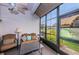 Comfortable enclosed patio with fan, furniture, and view to the green backyard and surrounding landscape at 9636 Brookdale Dr, New Port Richey, FL 34655