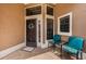 Inviting covered front entrance with chairs and a glass side table for relaxing at 9636 Brookdale Dr, New Port Richey, FL 34655