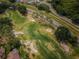 Aerial view of golf course with mature trees, sand traps, and manicured green at 9636 Brookdale Dr, New Port Richey, FL 34655