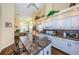 Open kitchen layout with white cabinetry, island, and modern appliances flowing into the dining area at 9636 Brookdale Dr, New Port Richey, FL 34655