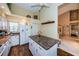 Kitchen with island, white cabinets, wood floors, and view to the dining room at 9636 Brookdale Dr, New Port Richey, FL 34655