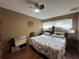 Cozy bedroom featuring a ceiling fan, natural light, and warm-toned walls at 10619 Mira Vista Dr, Port Richey, FL 34668