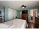 Bedroom with wood floors, closet and bathroom access, and a ceiling fan at 10619 Mira Vista Dr, Port Richey, FL 34668