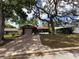 Home featuring mature trees shading the front yard and a long driveway at 10619 Mira Vista Dr, Port Richey, FL 34668