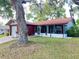 Charming home with a red brick facade, attached garage, and a screened-in porch at 10619 Mira Vista Dr, Port Richey, FL 34668