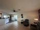 Spacious living room with tile floors, ceiling fan, and view of the kitchen and sunroom at 10619 Mira Vista Dr, Port Richey, FL 34668
