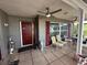 Charming front porch featuring a red door, brick accents, outdoor seating and ceiling fans at 10619 Mira Vista Dr, Port Richey, FL 34668