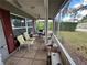Relaxing screened porch with comfortable seating and ceiling fan, perfect for enjoying the outdoors at 10619 Mira Vista Dr, Port Richey, FL 34668
