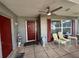Charming porch features a red door, brick accents, ceiling fan, and outdoor seating for relaxing at 10619 Mira Vista Dr, Port Richey, FL 34668