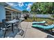 Outdoor patio with dining set, lounge chairs, and grill offers ample space for entertaining at 1074 Woodbrook S Dr, Largo, FL 33770