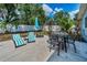 Backyard patio boasts lounge chairs, dining set, and umbrella for stylish outdoor living at 1074 Woodbrook S Dr, Largo, FL 33770
