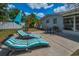 Backyard patio with lounge chairs, dining set, and umbrella offer comfort and shade at 1074 Woodbrook S Dr, Largo, FL 33770