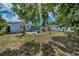 A secluded backyard with patio, lounging and dining seating, surrounded by mature trees at 1074 Woodbrook S Dr, Largo, FL 33770