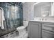 Modern bathroom with a glass enclosed shower, gray vanity, and stylish tile flooring at 1074 Woodbrook S Dr, Largo, FL 33770