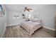Sunlit bedroom with a ceiling fan, wood-look floors, and windows with coverings at 1074 Woodbrook S Dr, Largo, FL 33770