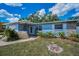 Charming blue home with stone accents, well-maintained landscaping, and an inviting entrance at 1074 Woodbrook S Dr, Largo, FL 33770