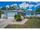 Charming light blue single-story home with a well-manicured lawn and stone accents at 1074 Woodbrook S Dr, Largo, FL 33770