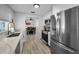 Open concept kitchen with stainless steel appliances, white cabinets, and view of dining room at 1074 Woodbrook S Dr, Largo, FL 33770