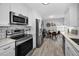 Bright kitchen features stainless steel appliances, white cabinets, and a breakfast nook at 1074 Woodbrook S Dr, Largo, FL 33770