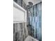 Stylish shower showcasing blue-toned tile, a window, and an updated shower head at 1074 Woodbrook S Dr, Largo, FL 33770