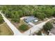 An aerial view of a charming blue home with a screened pool and a long driveway at 11379 Flower Ave, Weeki Wachee, FL 34613