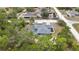 Aerial view showcasing a beautiful home with a screened pool in a lush, green neighborhood at 11379 Flower Ave, Weeki Wachee, FL 34613