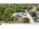 Expansive aerial view showcasing the house with a screened pool, complemented by lush trees and scenic landscape at 11379 Flower Ave, Weeki Wachee, FL 34613