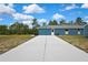 Expansive backyard featuring a concrete driveway and lush green lawn, ideal for outdoor activities at 11379 Flower Ave, Weeki Wachee, FL 34613